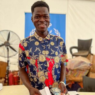 Asylum seeker from Burkina Faso displaying cash received from WFP at the Tarikom Reception Center, Upper East Region